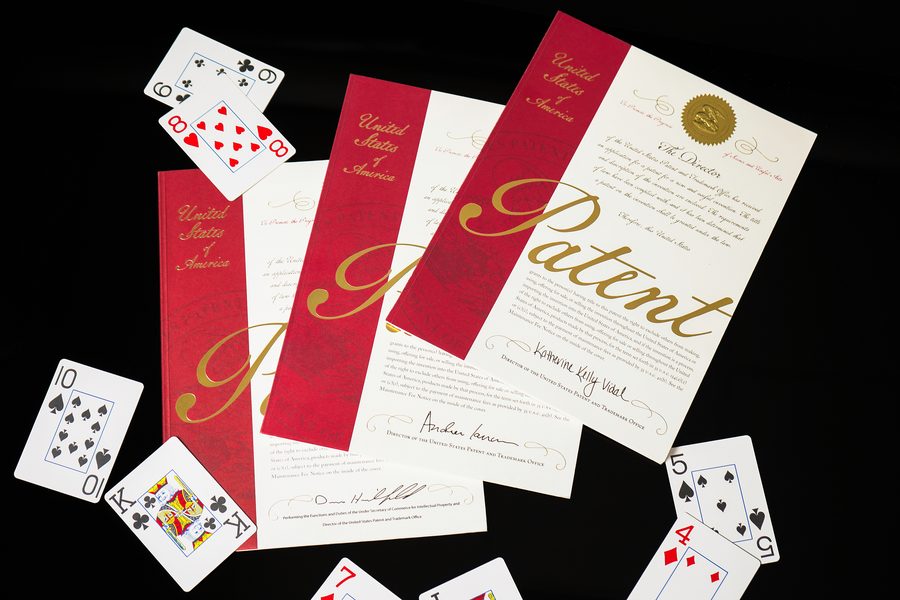 U.S. patent certificates for 2 Hand Hold’em and Badugi Chase among playing cards